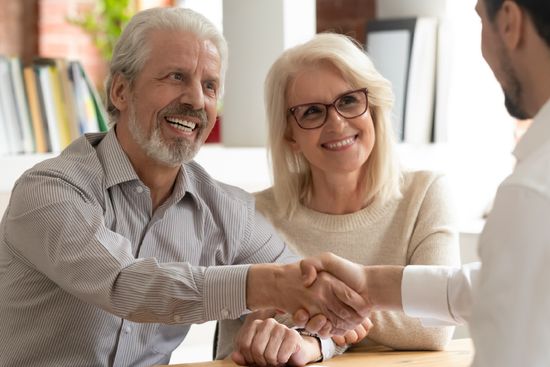 couple shaking hands with lawyer